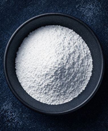 A bowl of glycine powder in blue duotone